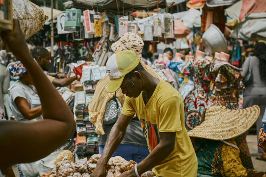 Man selling food at market in African city