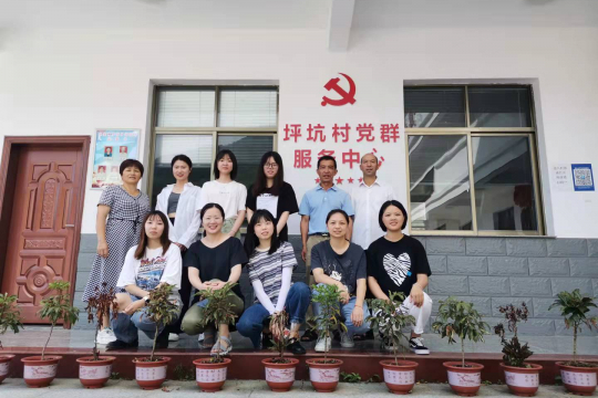 Survey team of Fujian province and local village leaders in front of a village center
