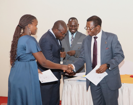 A graduating fellow receiving the certificate from Prof. Buyinza Mukadasi