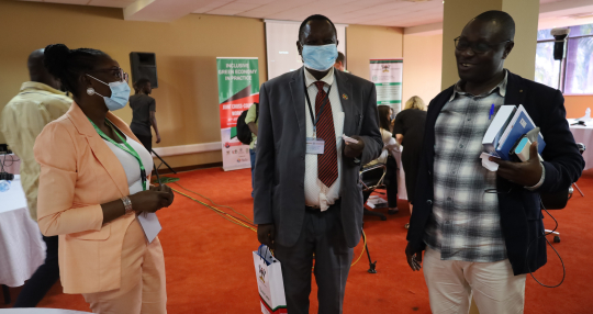 Collins Oloya interacts (centre) interacts with some IGE fellows after the closing ceremony