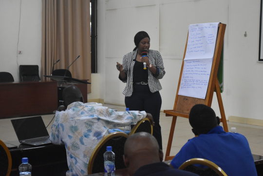 A participant steps forward to present key insights from the group discussion.  