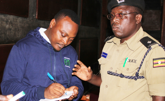 EfD-Mak Data Manager Fred Kasalirwe interacts with the police commander after the meeting. Photo:EfD-Mak centre
