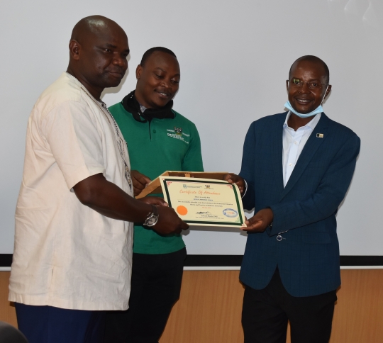 Hon. MP Lawrence Songa gets te Certificate of Attendance fro Prof. Edward Bbaale