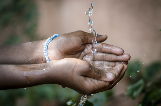 Water dripping onto open hands