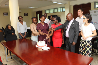 Centre Director Prof. Edward Bbaale and staff cutting a cake in honor Internee Ruth Asiimwe for the job welldone :Photo by Jane Anyango