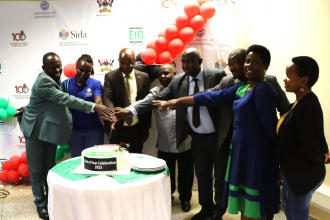 Policy engagement specialist and Centre Director plus other stakeholder representatives cutting the end year cake
